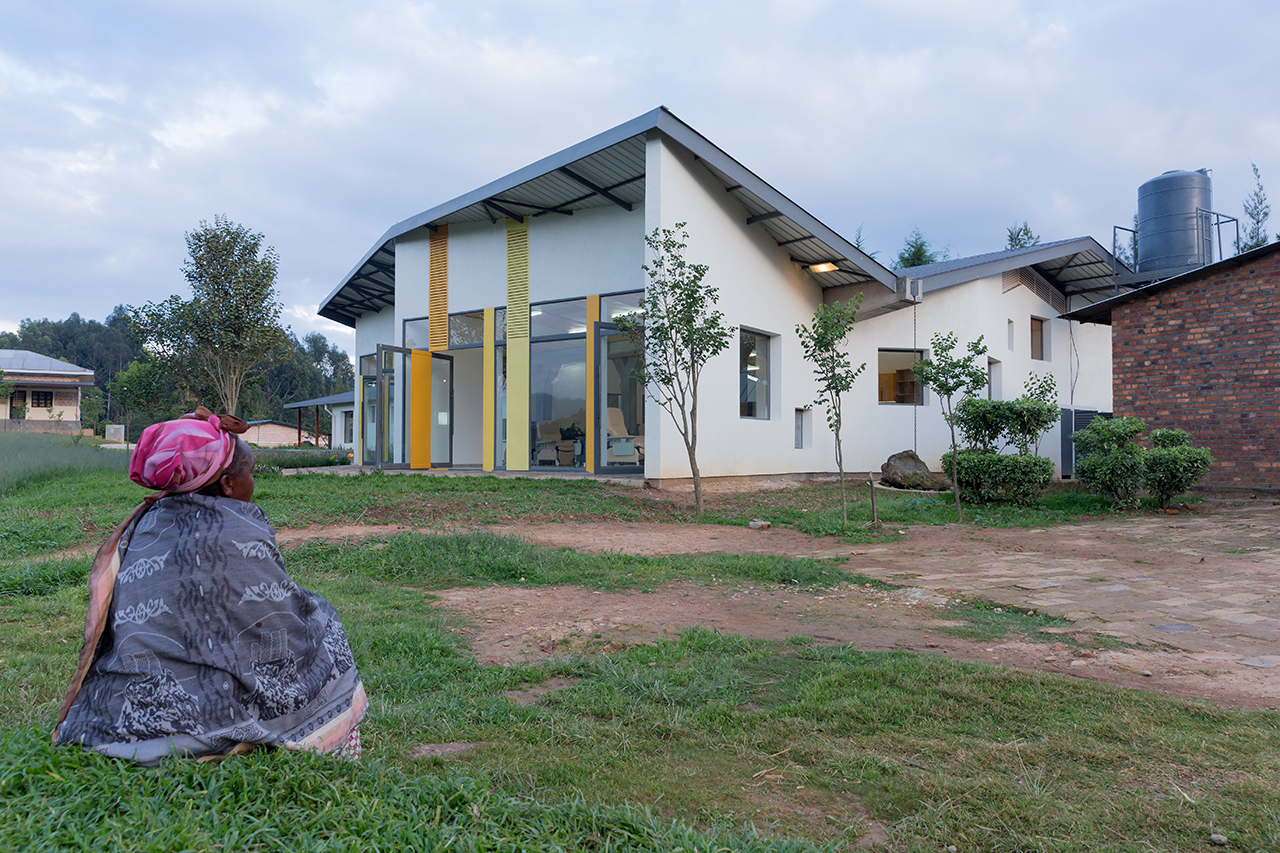 Photo of Butaro Ambulatory Cancer Center, Photo by Iwan Baan, Daytime Exterior of the Building with Woman
