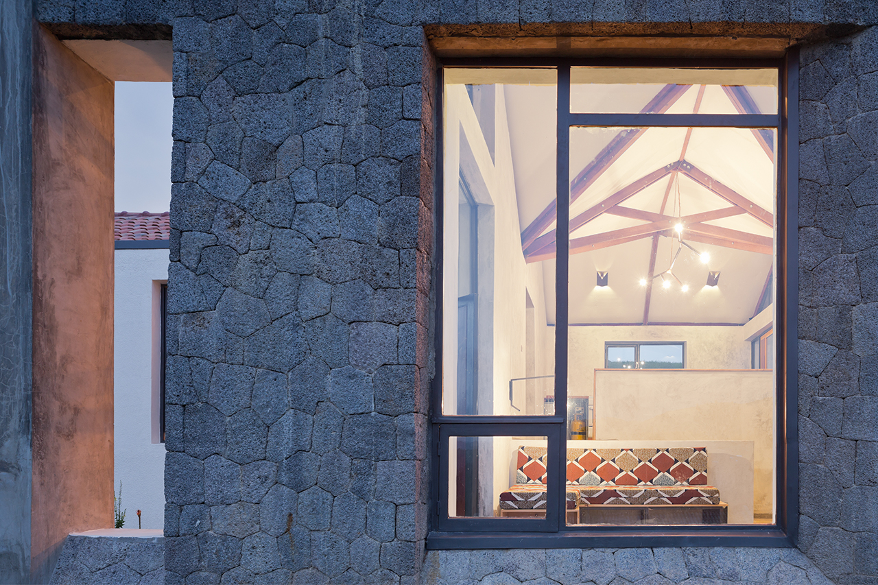 Photo of Butaro Doctors' Housing, Photo by Iwan Baan, Nightime View of Window Frame and View into Living Room