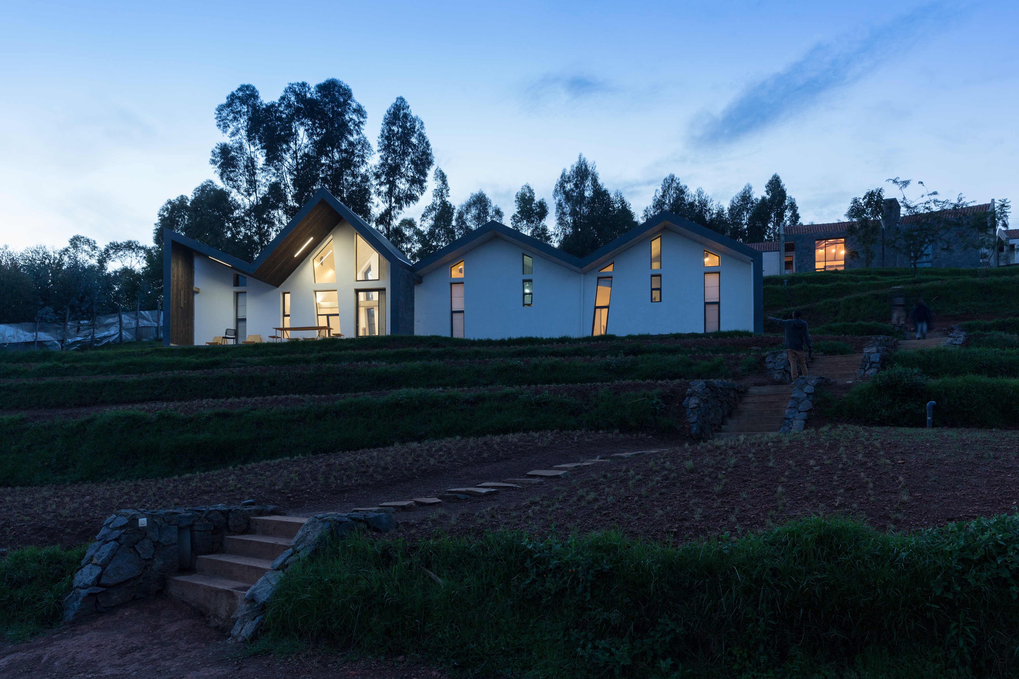 Photo of Butaro Doctors' Sharehousing, Photo by Iwan Baan, Exterior Evening View of the Hill Side and a Housing Unit