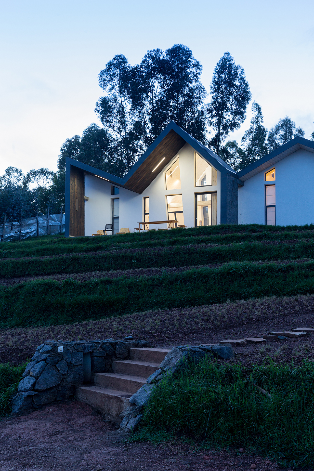 Photo of Butaro Doctors' Sharehousing, Photo by Iwan Baan, Exterior Evening View of the Hill Side and a Housing Unit