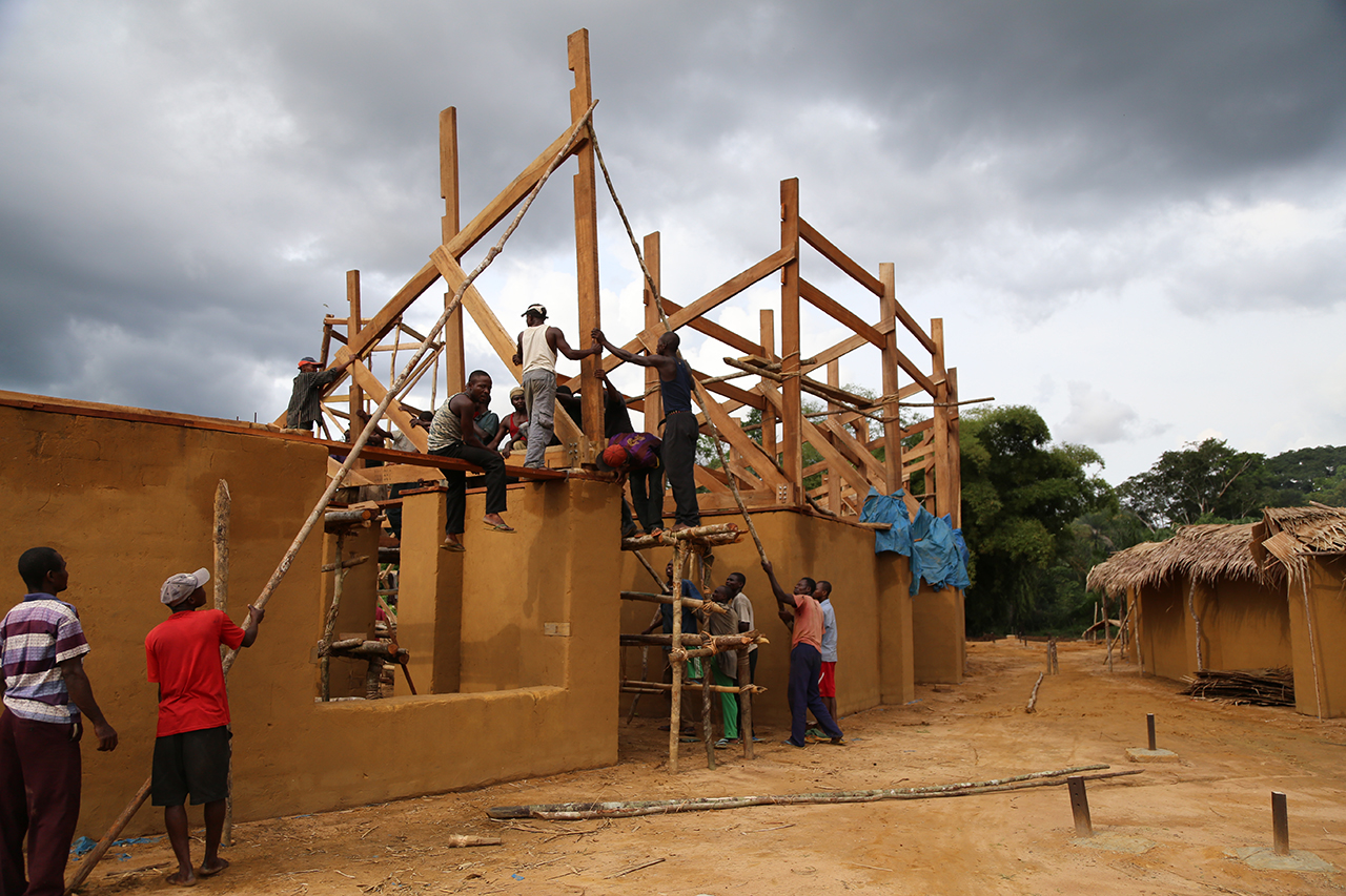 Photo of Ilima Primary School, Community Members hoisting the truss for the school roof