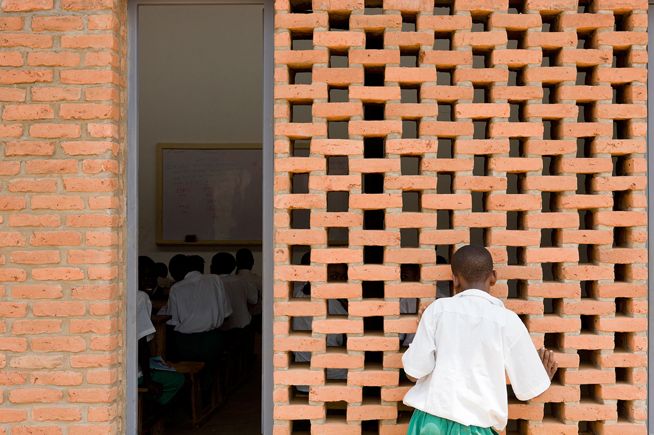 Photo of the Umubkano Primary School, Photo by Iwan Baan, View of Custom Brick Wall with Gaps for Ventilation into Primary School Classroom